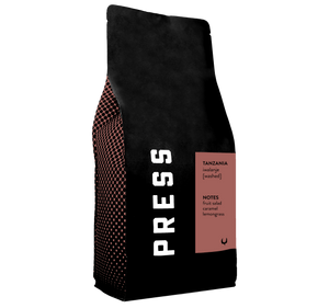 A side view of Tanzania iwalanje washed process coffee bag. Featuring notes of fruit salad, caramel, and lemongrass. 
